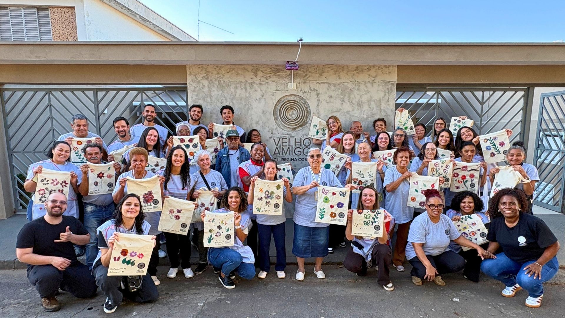 Participantes de ação de voluntariado exibem ecobags produzidas durante oficina realizada em parceria com o Instituto Velho Amigo.