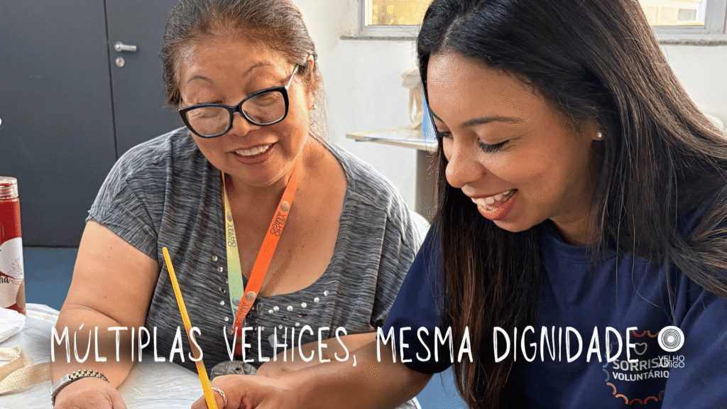Duas pessoas sentadas à mesa durante atividade educativa com materiais de pintura.